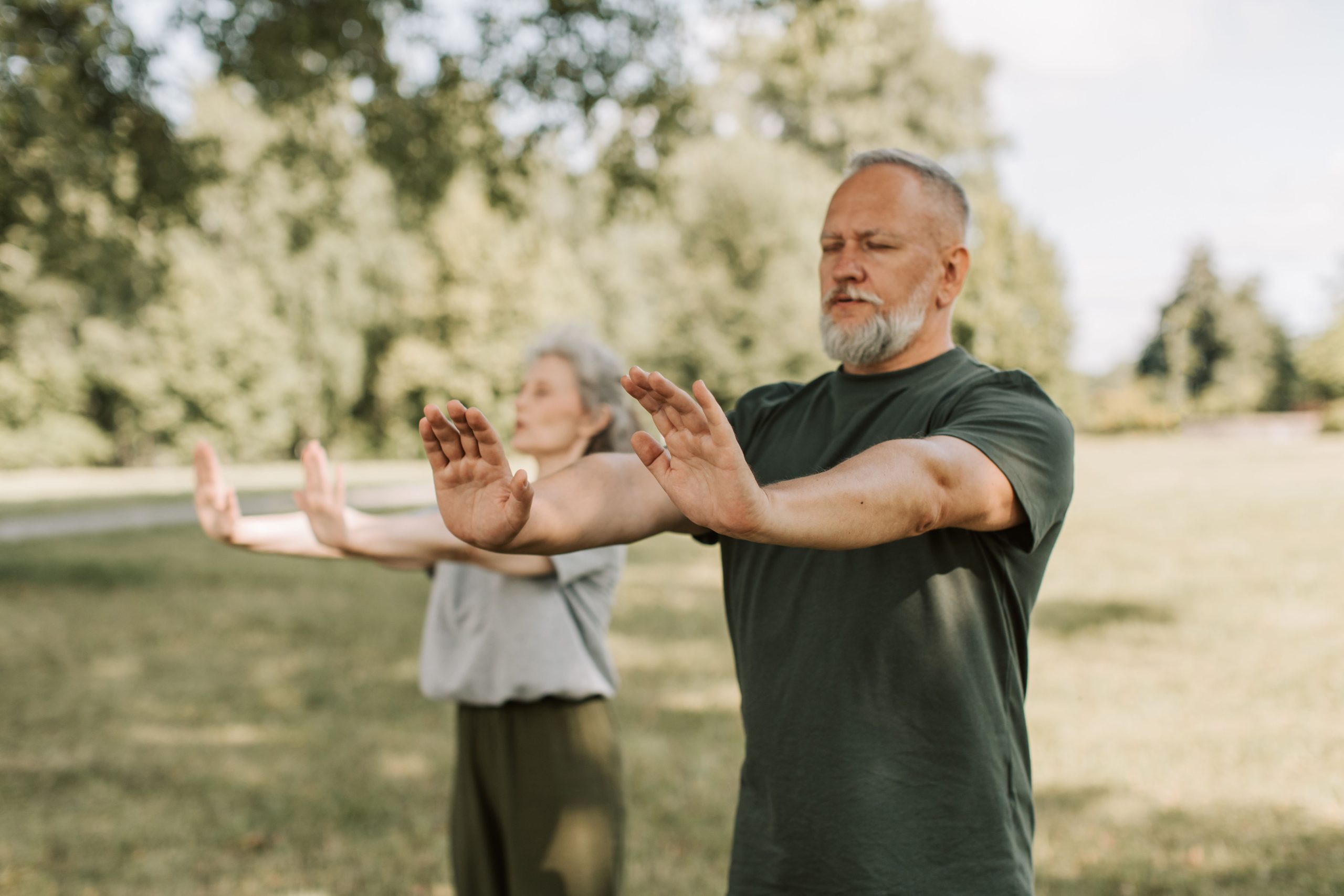 Tai Chi Chuan Practice in a Johannesburg Park Practitioner extending both arms in a Tai Chi Chuan (太極拳) posture outdoors in a park, with a second practitioner visible in the background